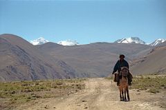 15 Local Villager Rides On A Horse By Our Lunch Spot With Everest North Face Poking Above Hill.jpg